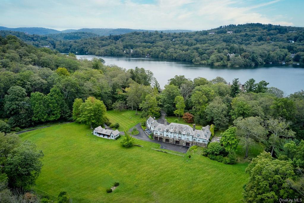 an aerial view of a house with a garden and lake view