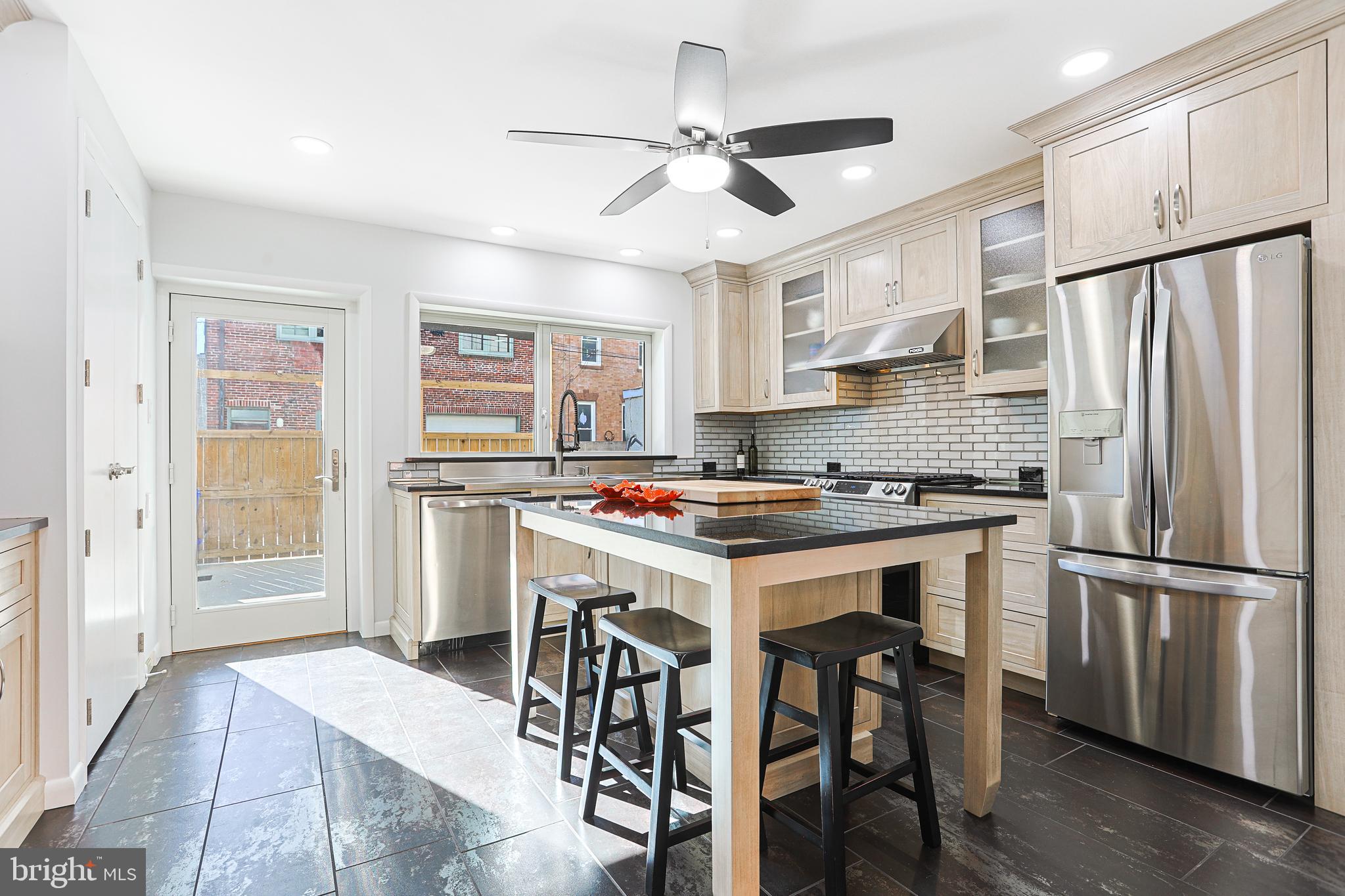 a kitchen with granite countertop a refrigerator a sink appliances and cabinets