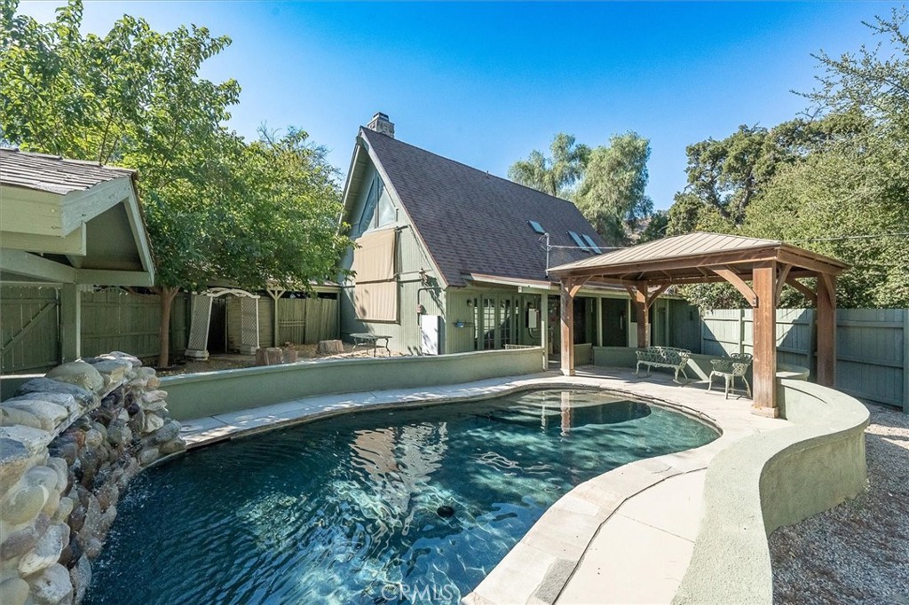 a swimming pool view with a seating space