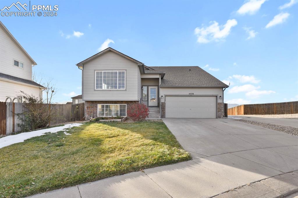 View of front of house featuring a garage and a front yard