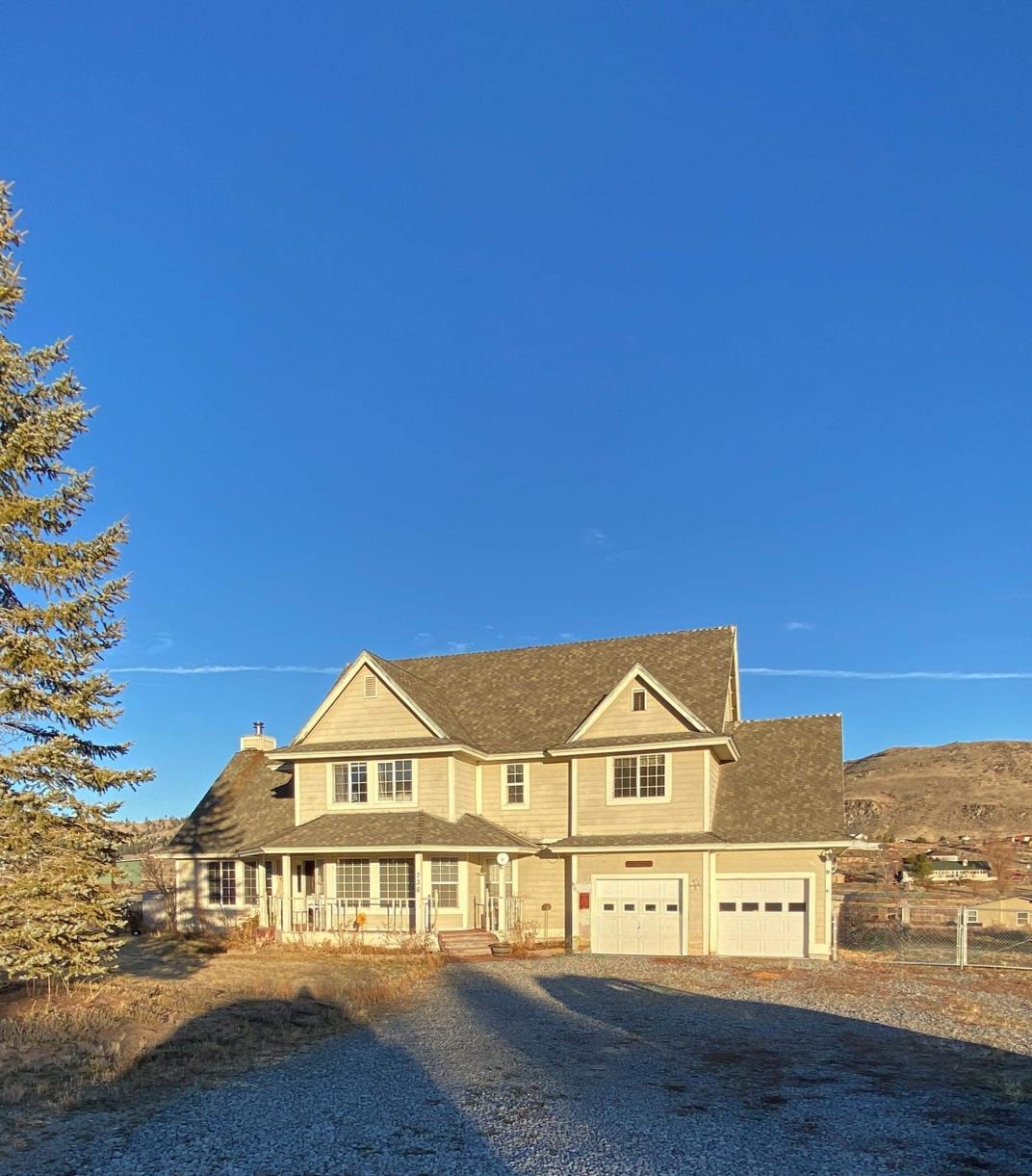 a view of a big house with a big yard and large trees