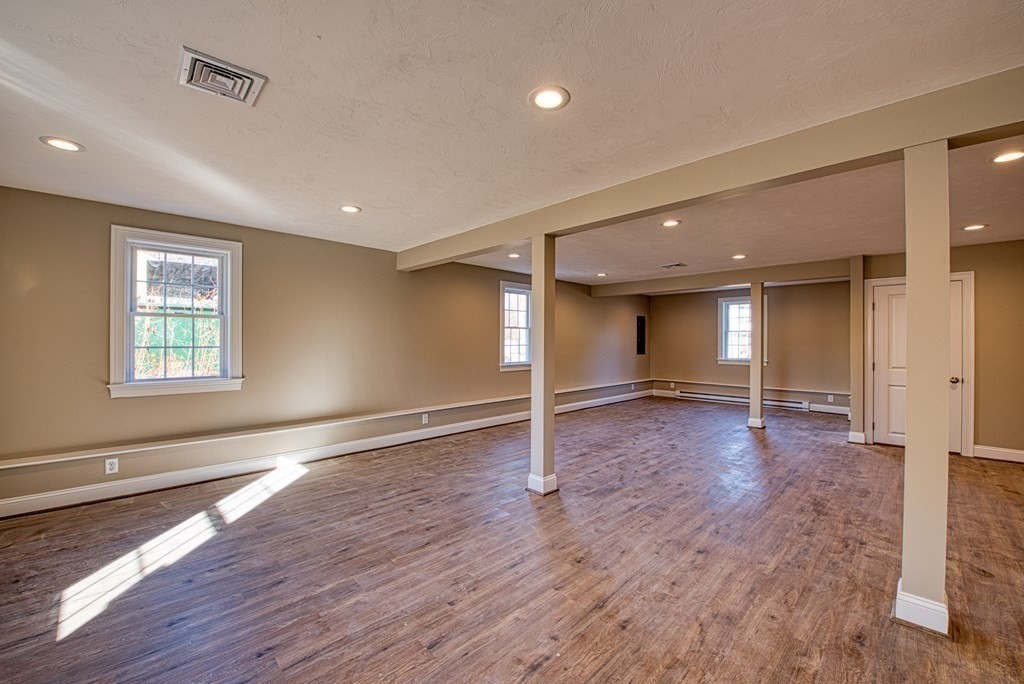 an empty room with wooden floor and window