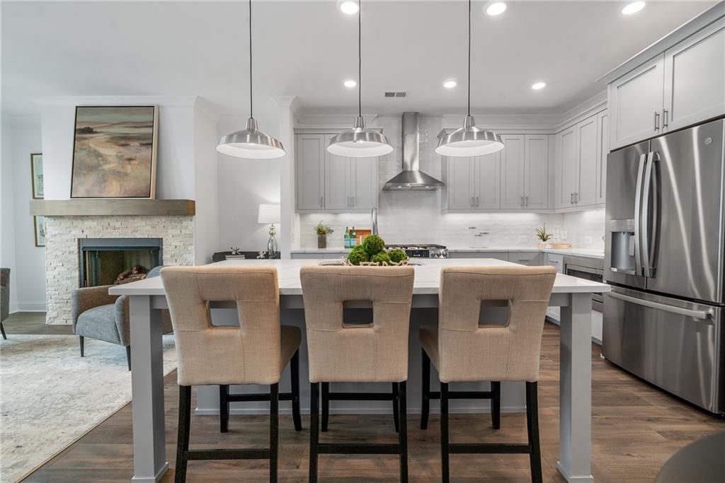 a kitchen with kitchen island a dining table and chairs