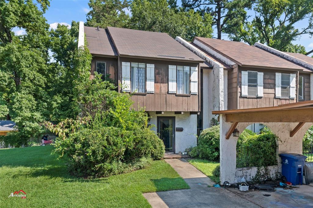 a aerial view of a house with a yard plants and large tree