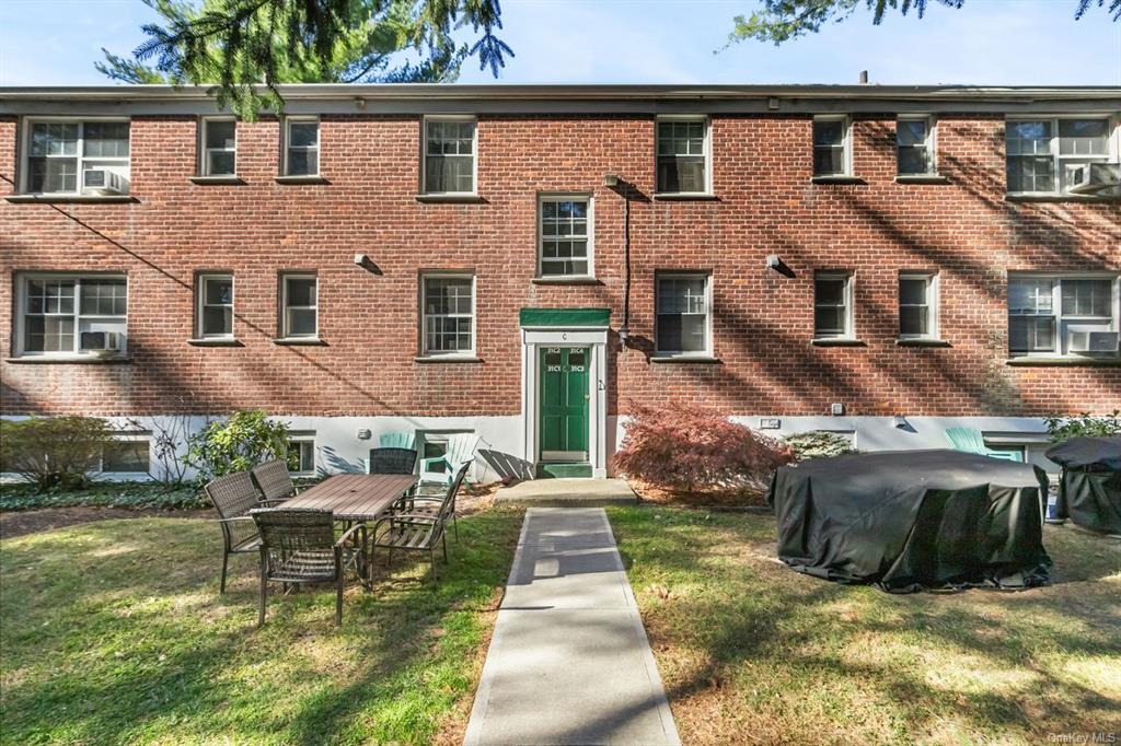 View of front of house featuring a front lawn and cooling unit