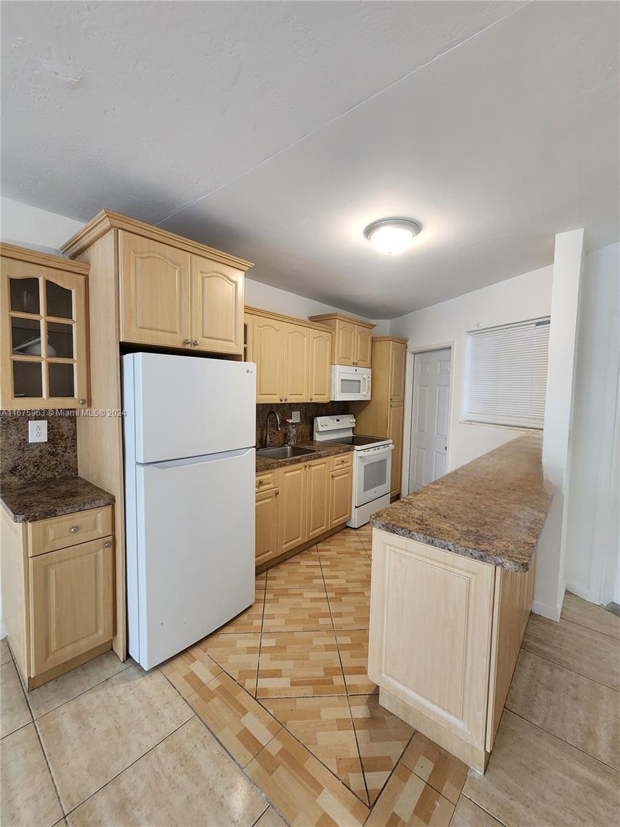 a kitchen with a sink a refrigerator and cabinets