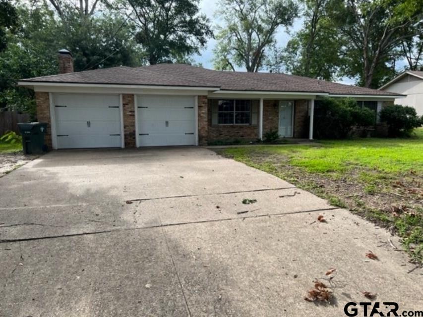 a view of a house with a yard and a large tree