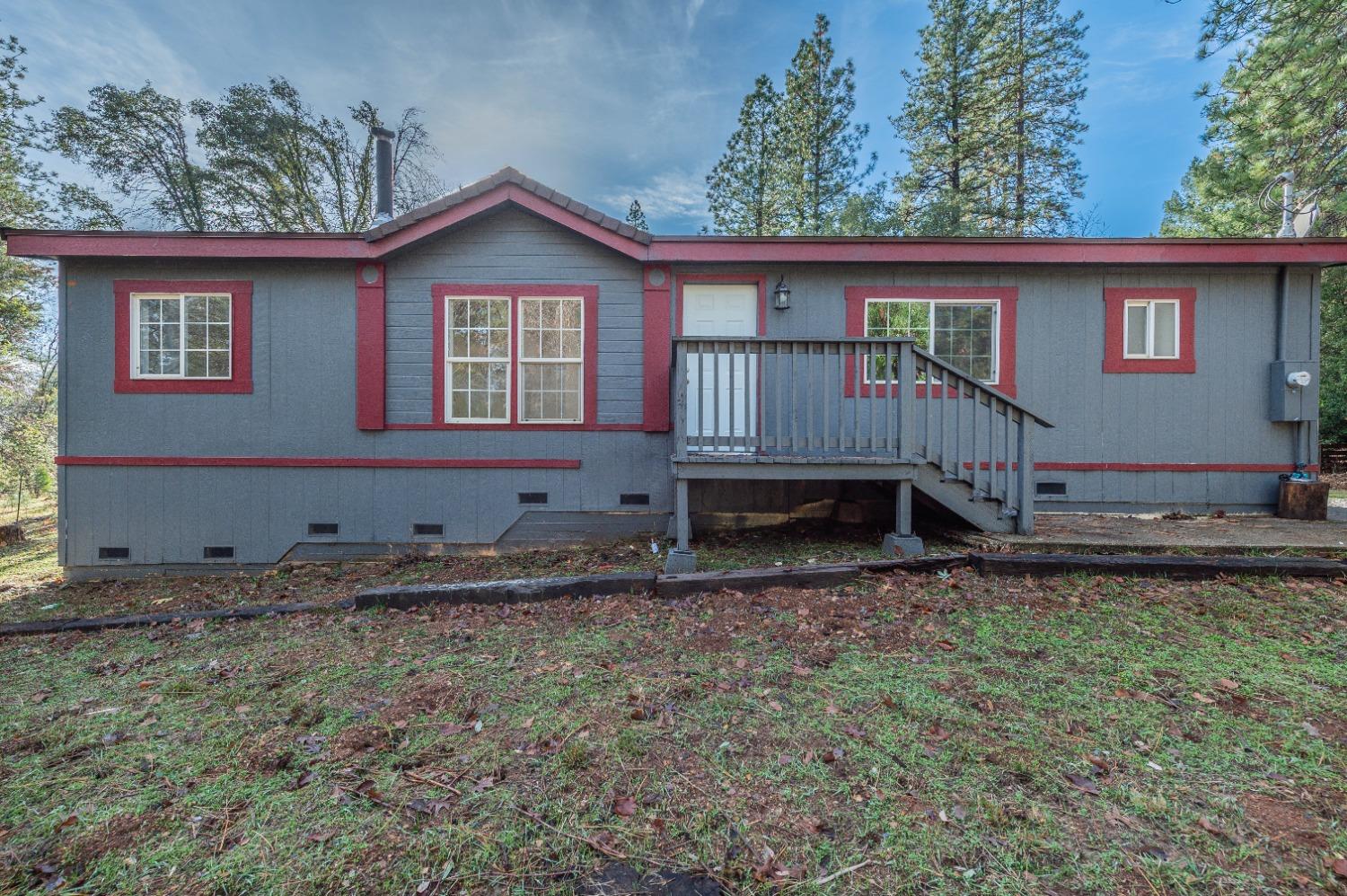 a view of a house with a yard and wooden fence