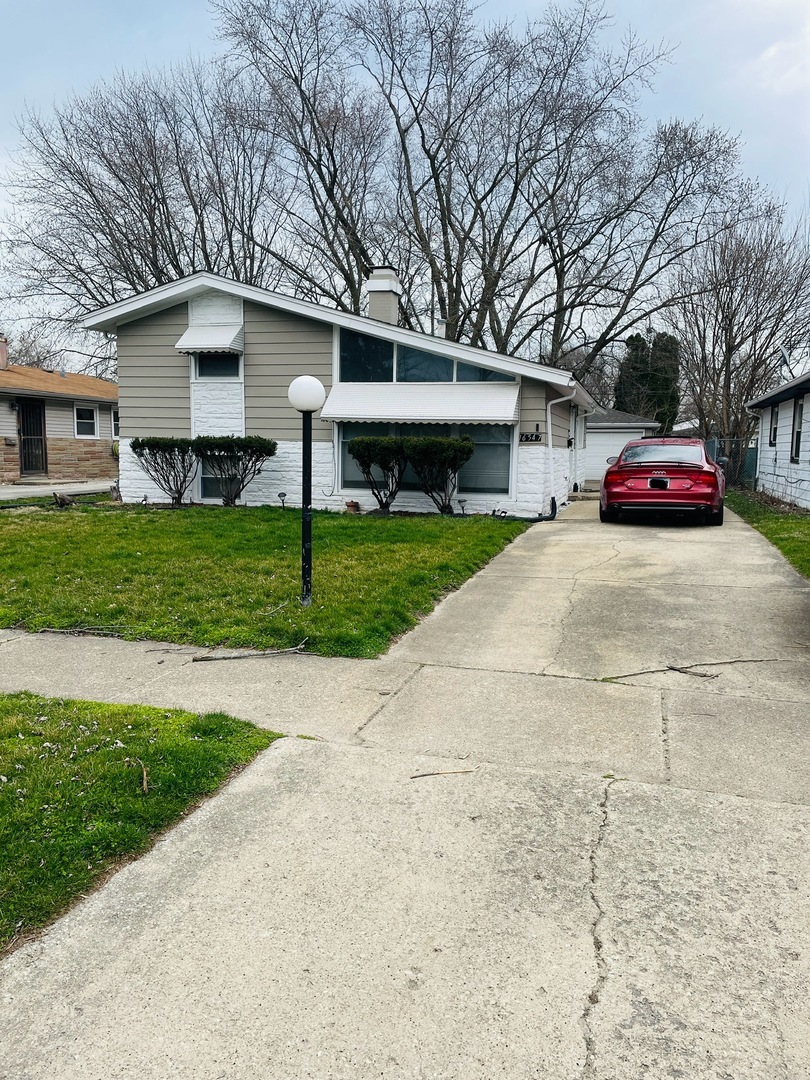 a view of a house with a yard and garage