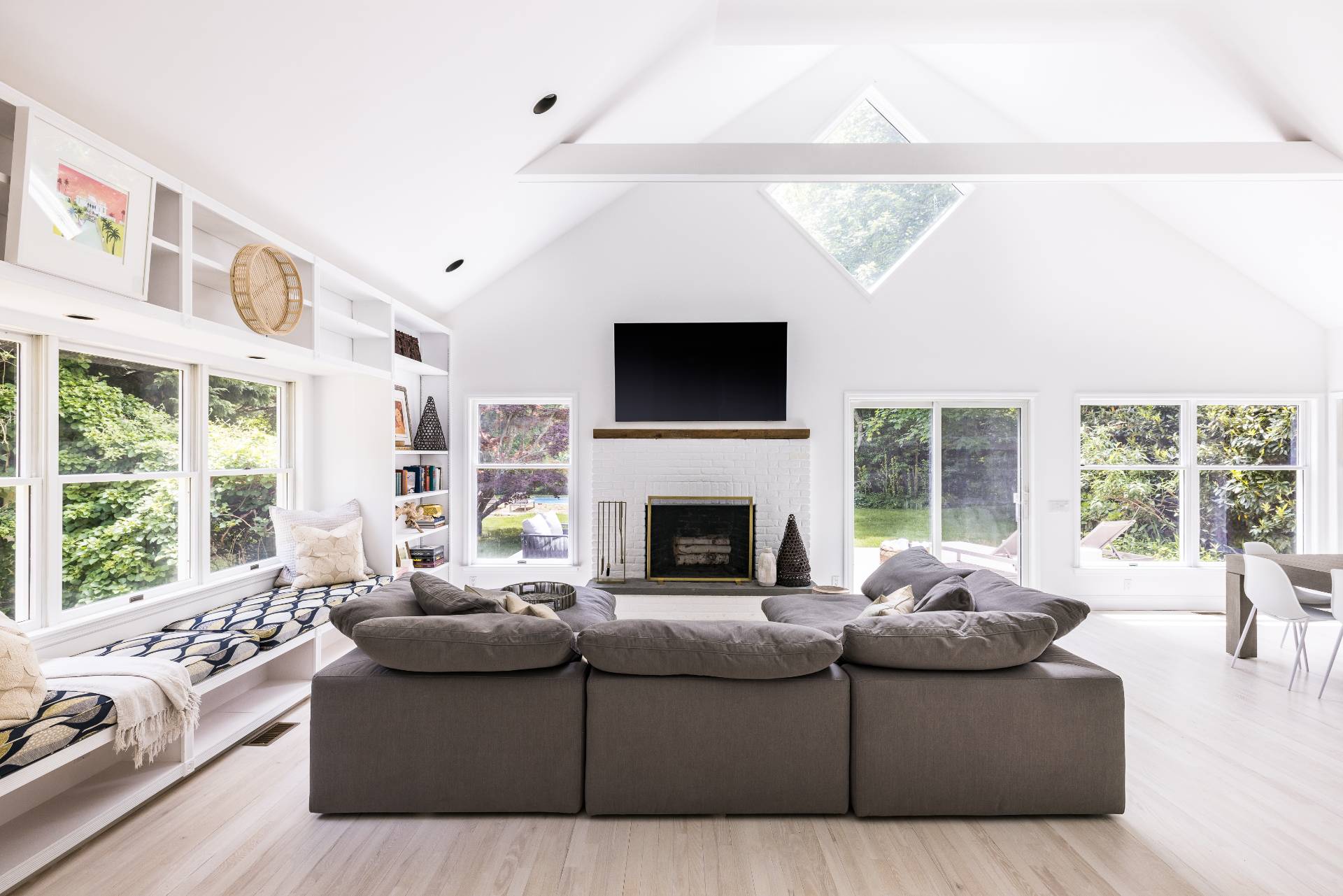 a living room with furniture a large window and a flat screen tv