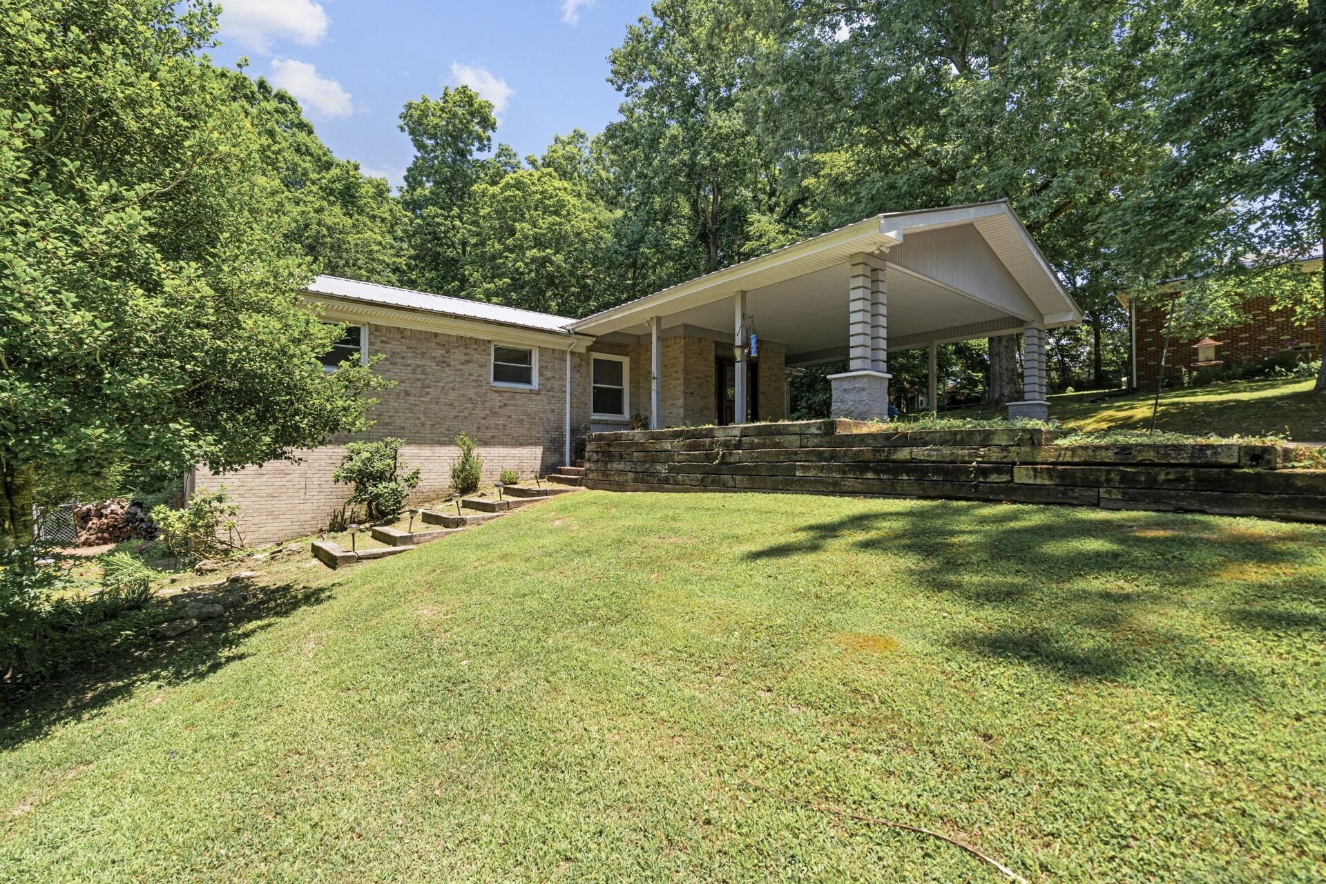 a front view of house with yard and trees around