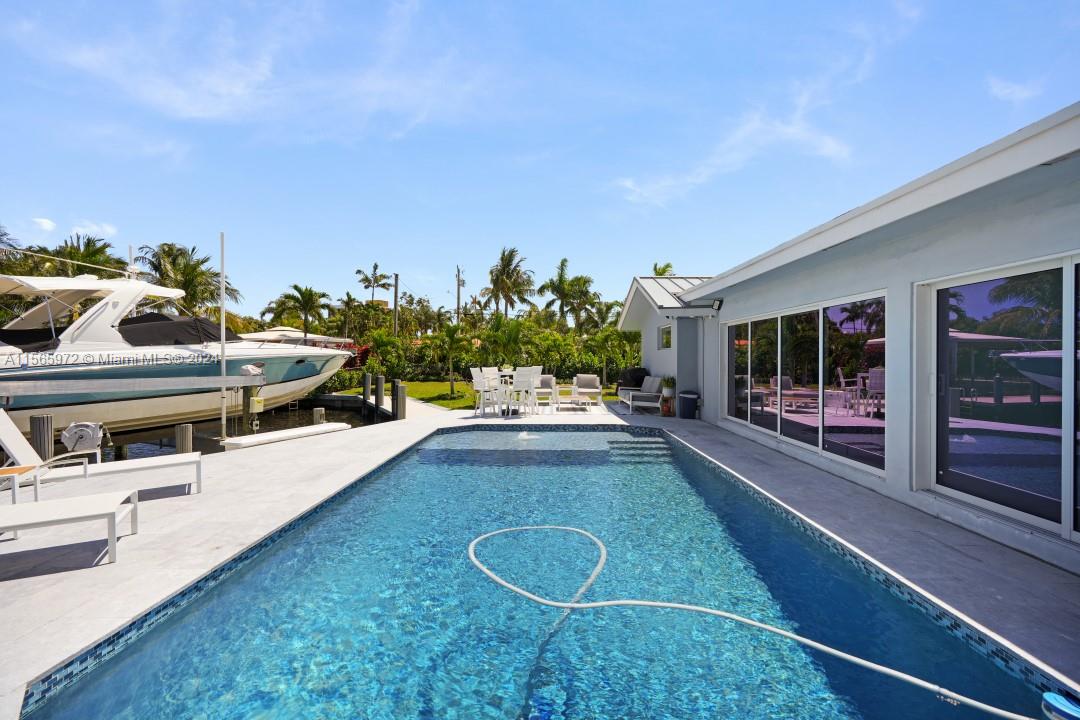 a swimming pool with outdoor seating and yard