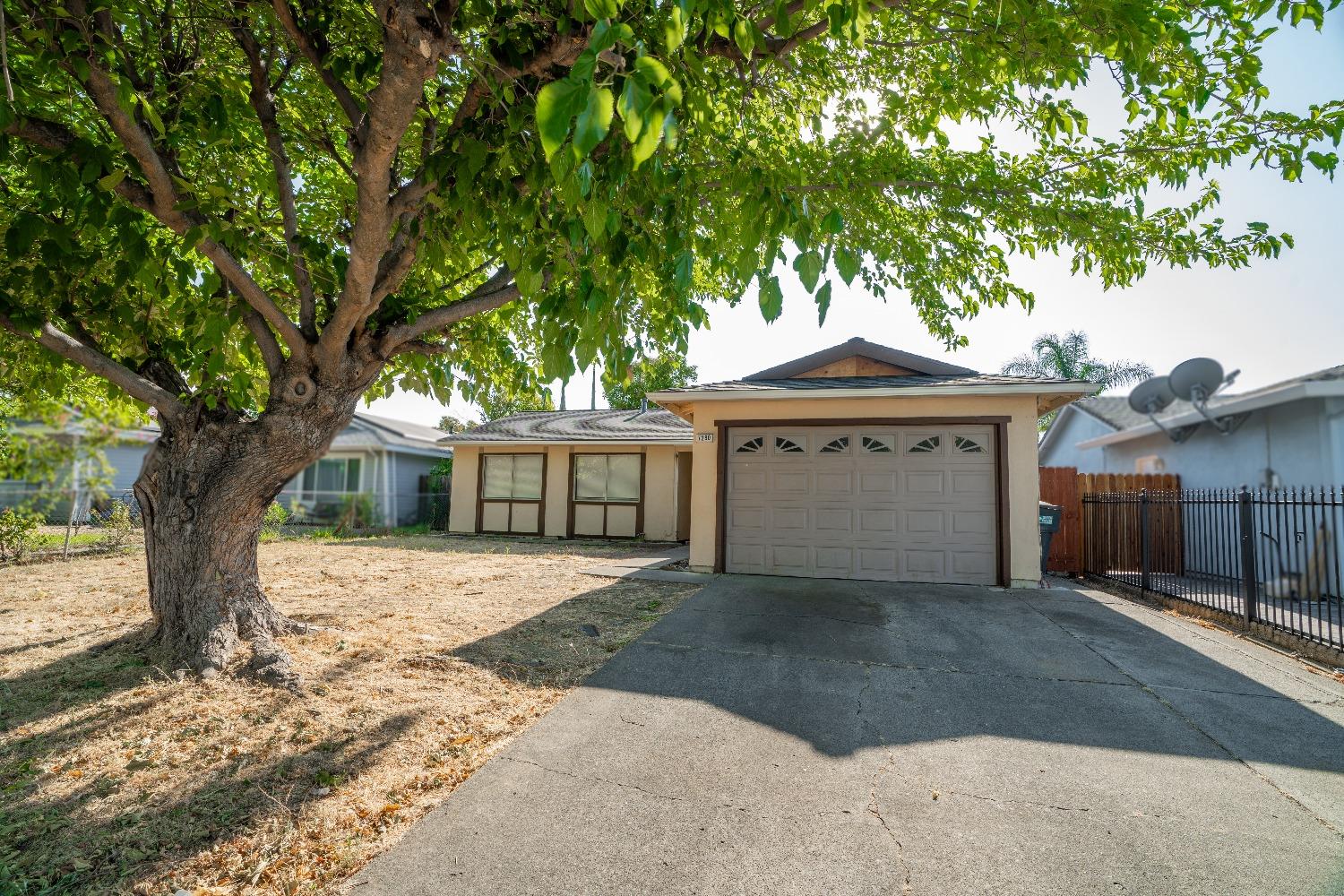 a front view of a house with a garden and trees