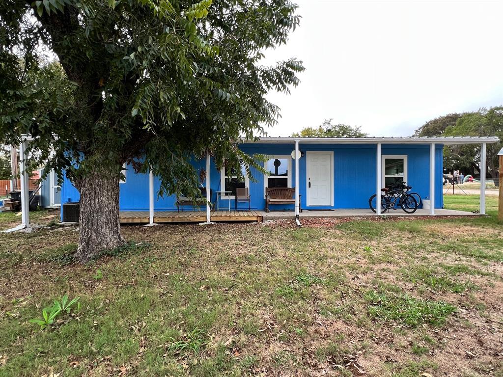 a front view of a house with a yard and tree