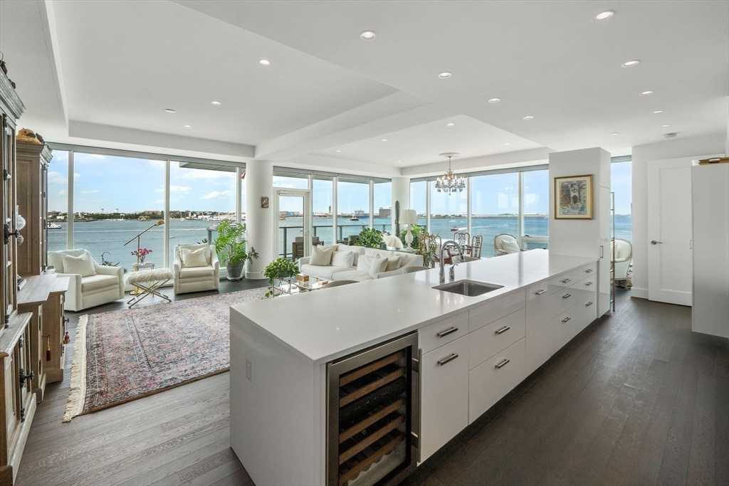 a large living room with stainless steel appliances kitchen island a large window