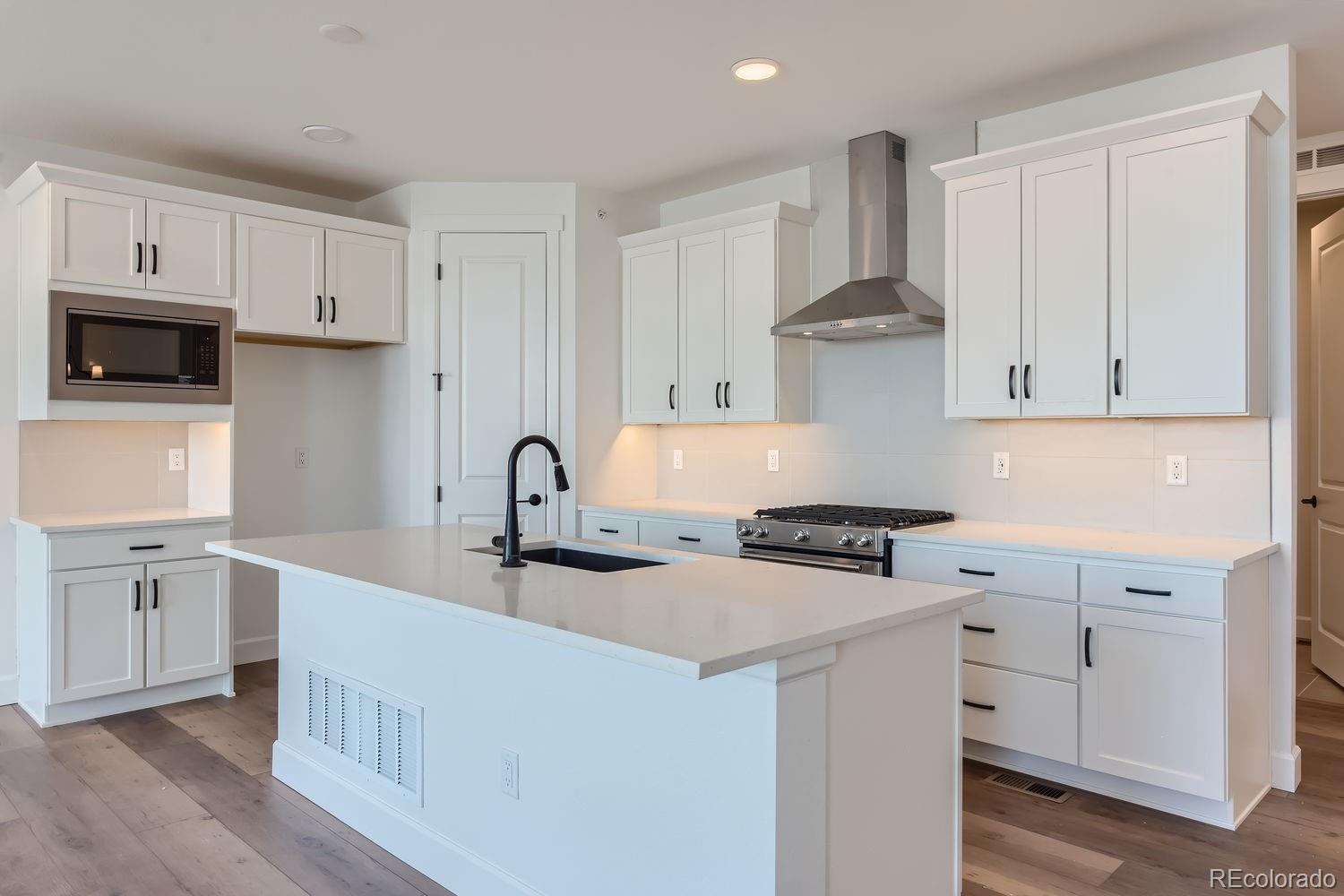 a kitchen with white cabinets and appliances