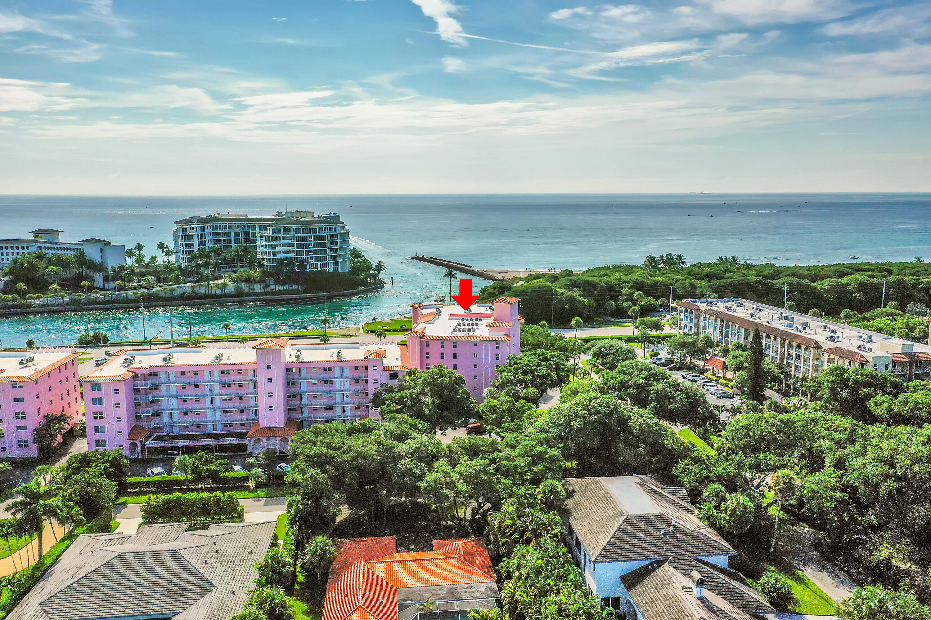 an aerial view of a city with lots of residential buildings ocean and mountain view in back