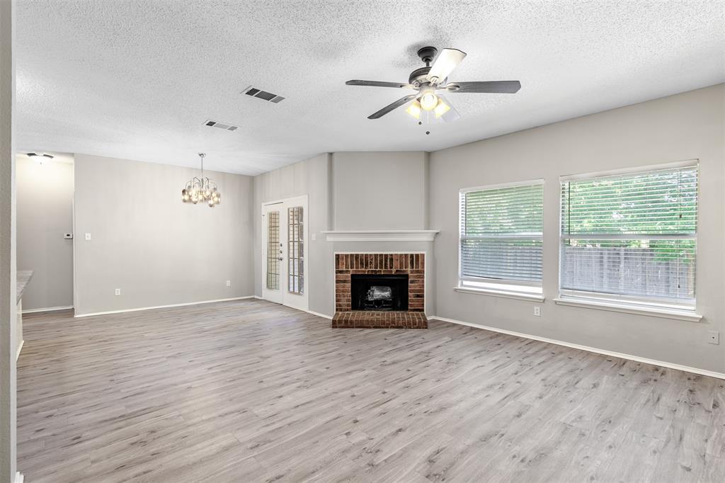 a view of an empty room with a fireplace and a window