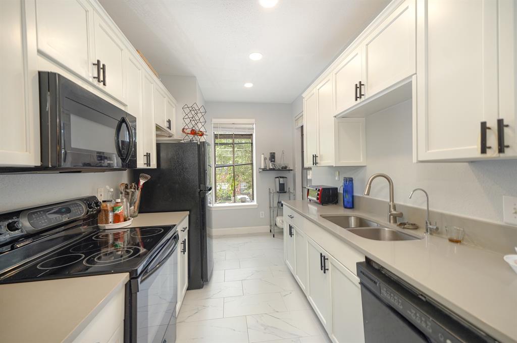 a kitchen with a sink stove top oven and refrigerator