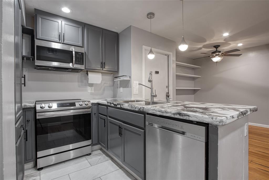 a kitchen with stainless steel appliances granite countertop a stove microwave and cabinets