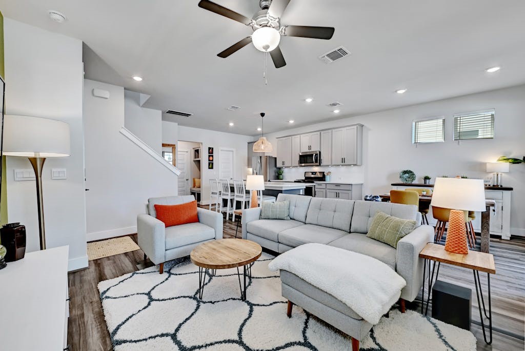 a living room with furniture kitchen view and a chandelier