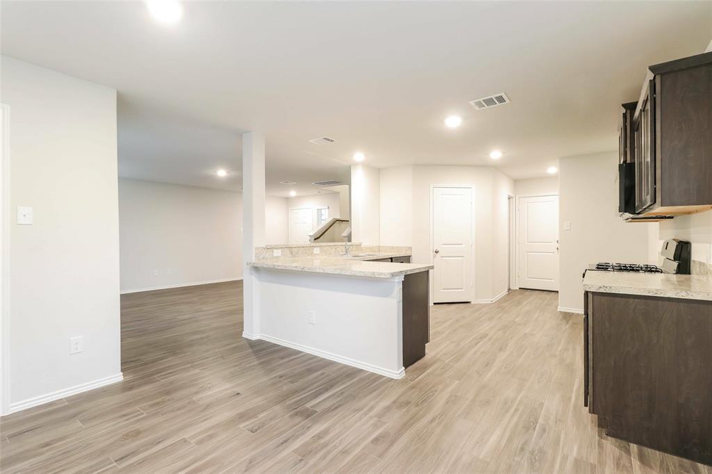 a large kitchen with kitchen island a sink stainless steel appliances and cabinets