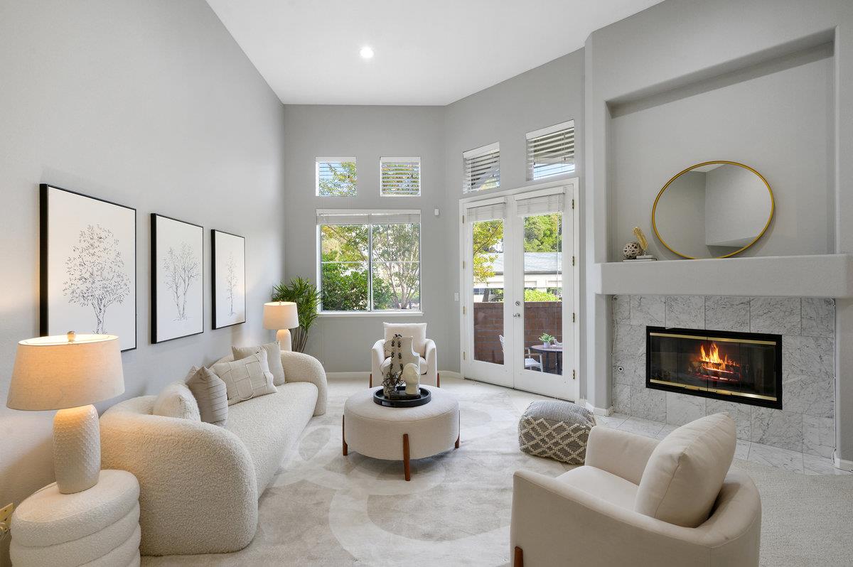 a living room with furniture a fireplace a large window and a large window