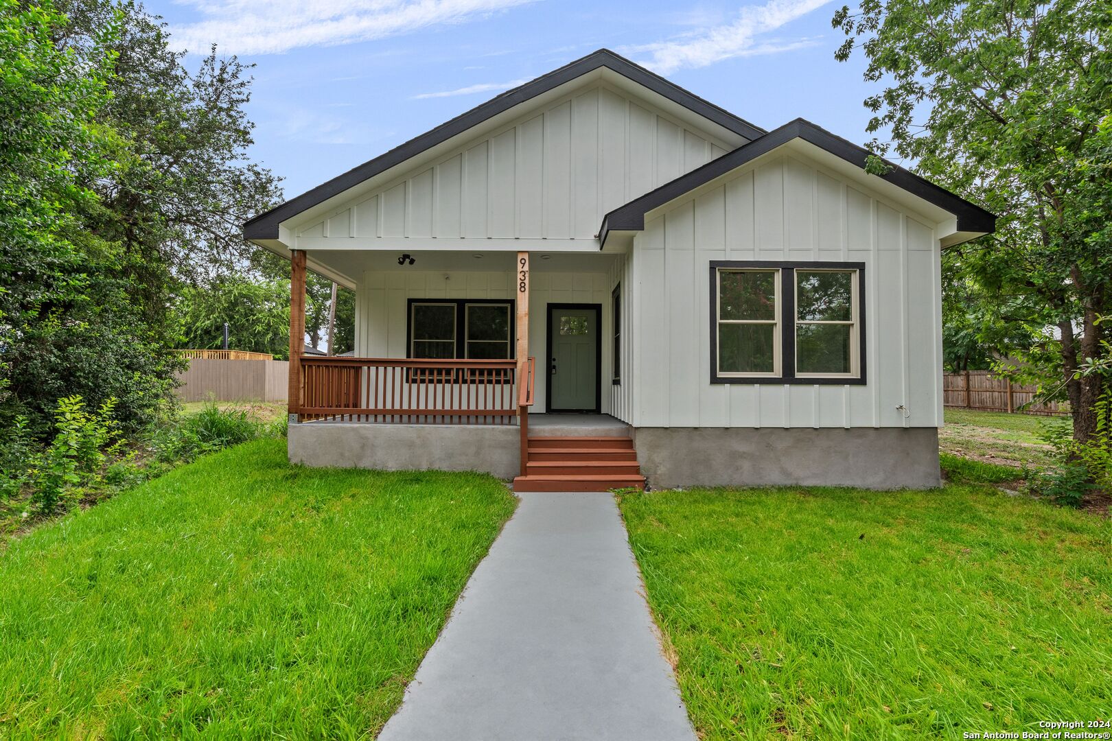 a front view of a house with a garden and yard