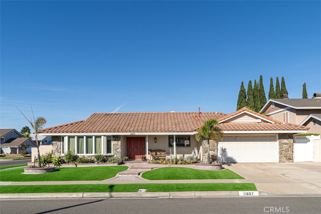 a front view of a house with a yard and potted plants