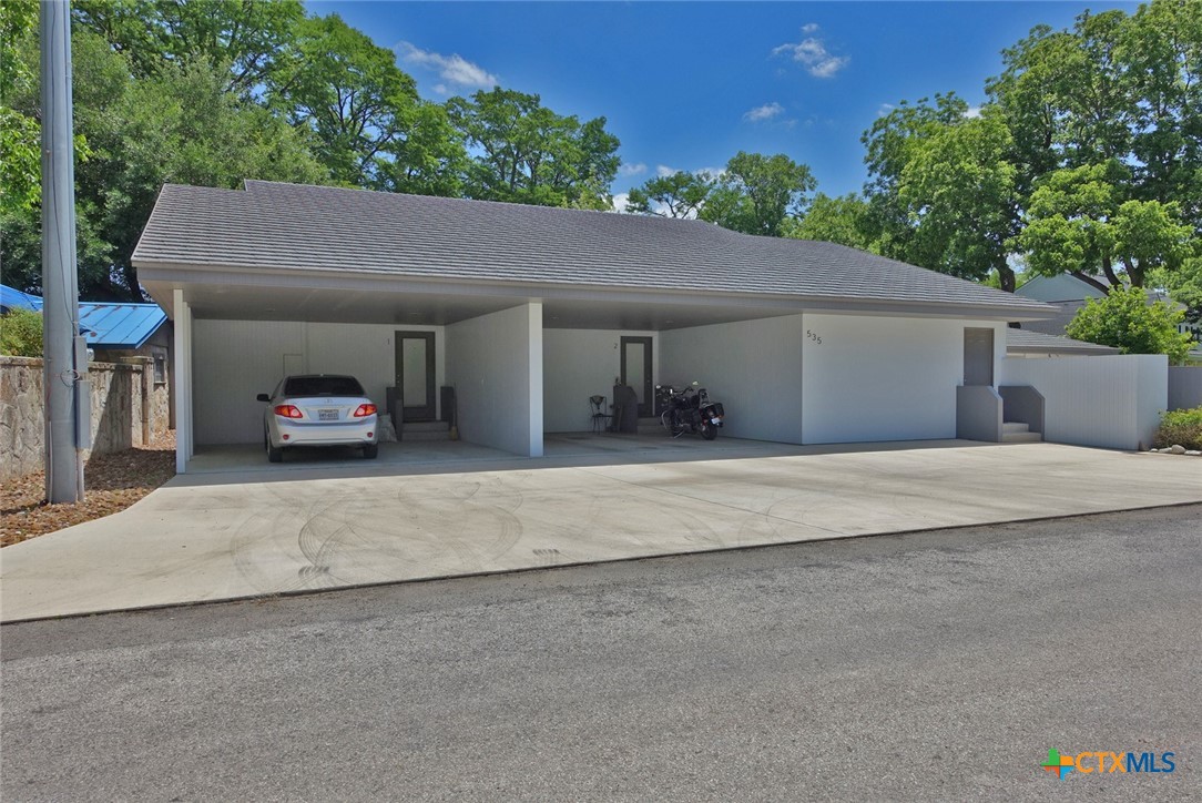 a view of garage with a car parked in front of it