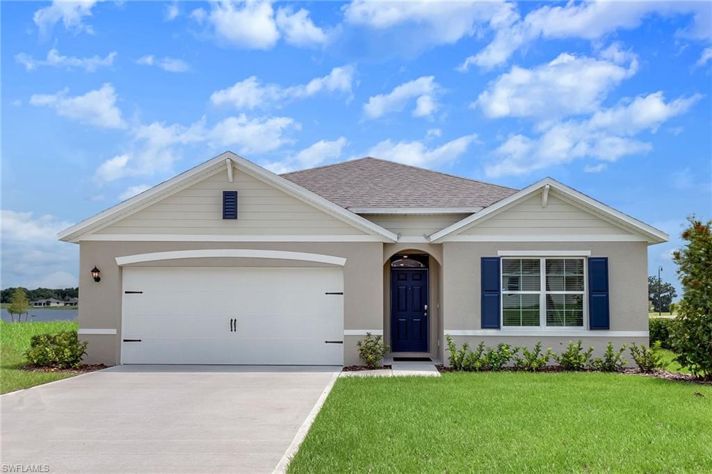 Ranch-style home featuring a garage and a front lawn