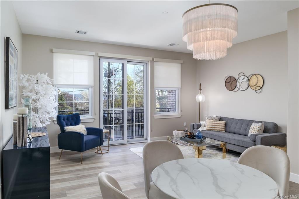 a living room with furniture chandelier and a large window