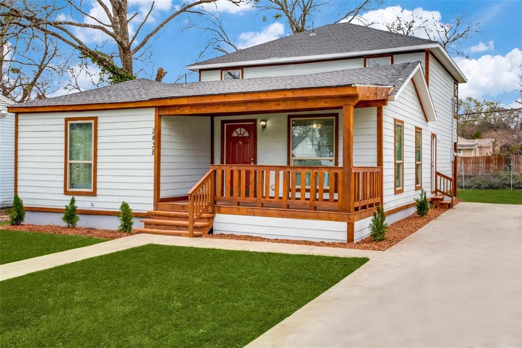 a view of a house with a yard porch and wooden fence