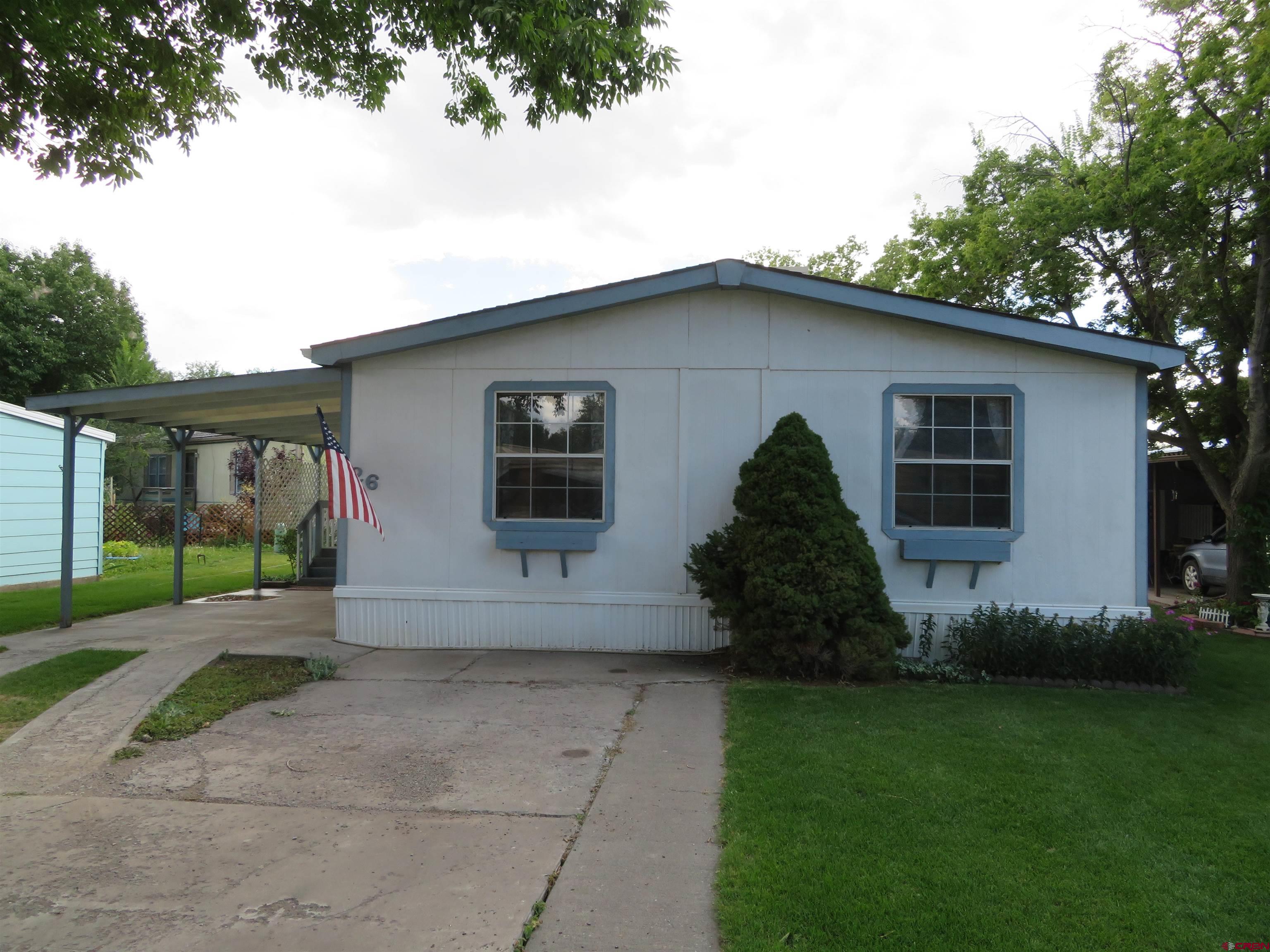 a front view of a house with a garden and yard