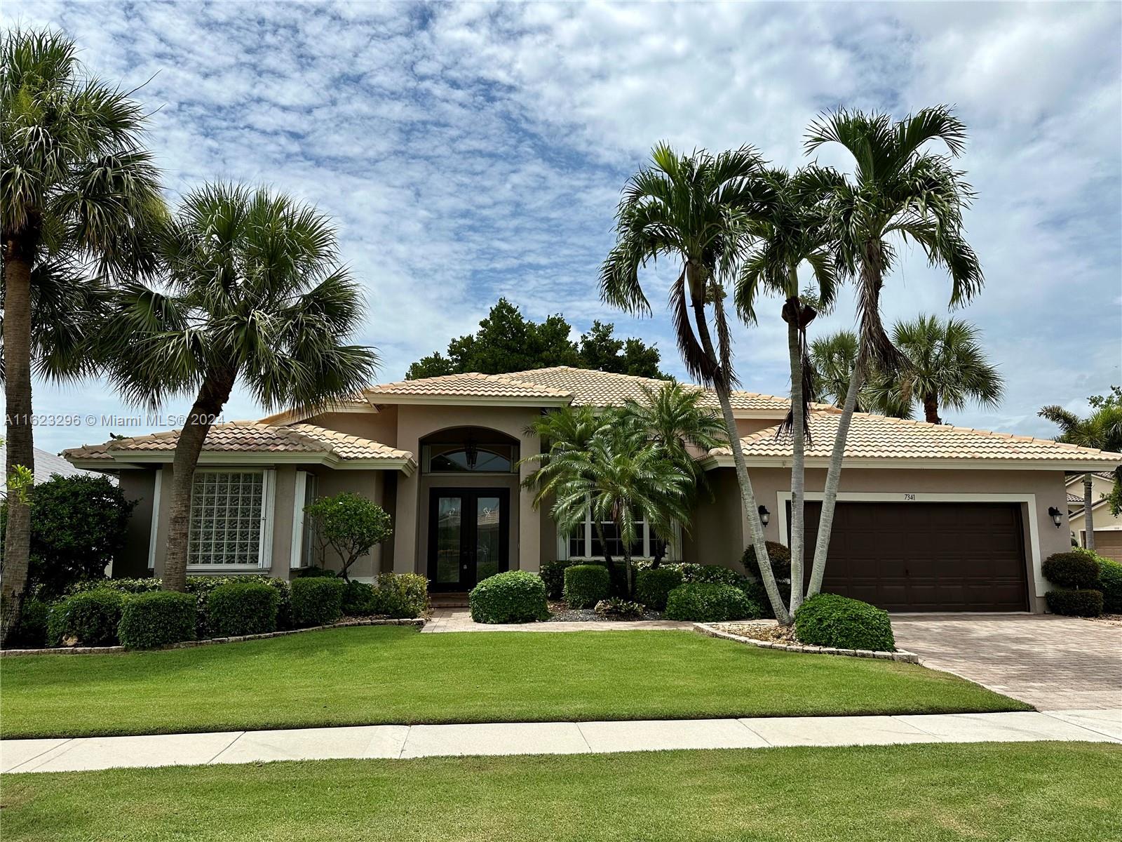 a front view of a house with a garden and yard