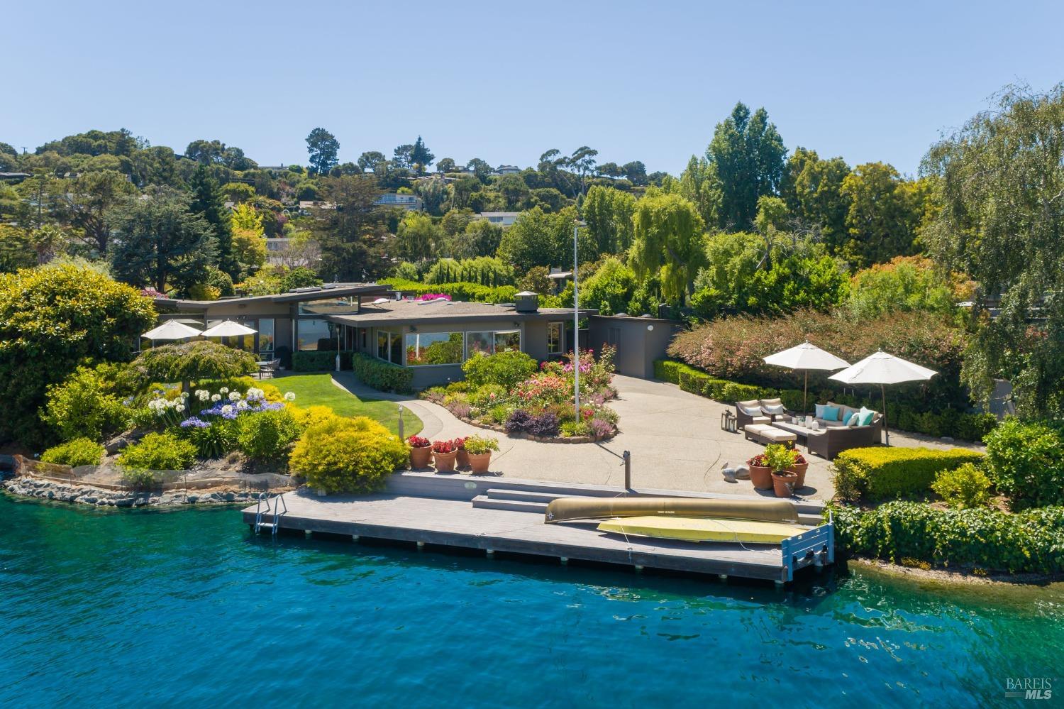 an aerial view of a house with a garden and lake view