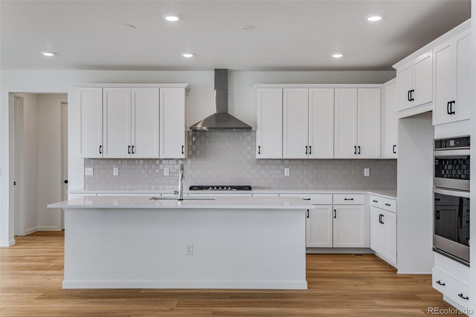 a kitchen with stainless steel appliances granite countertop a stove a sink and white cabinets