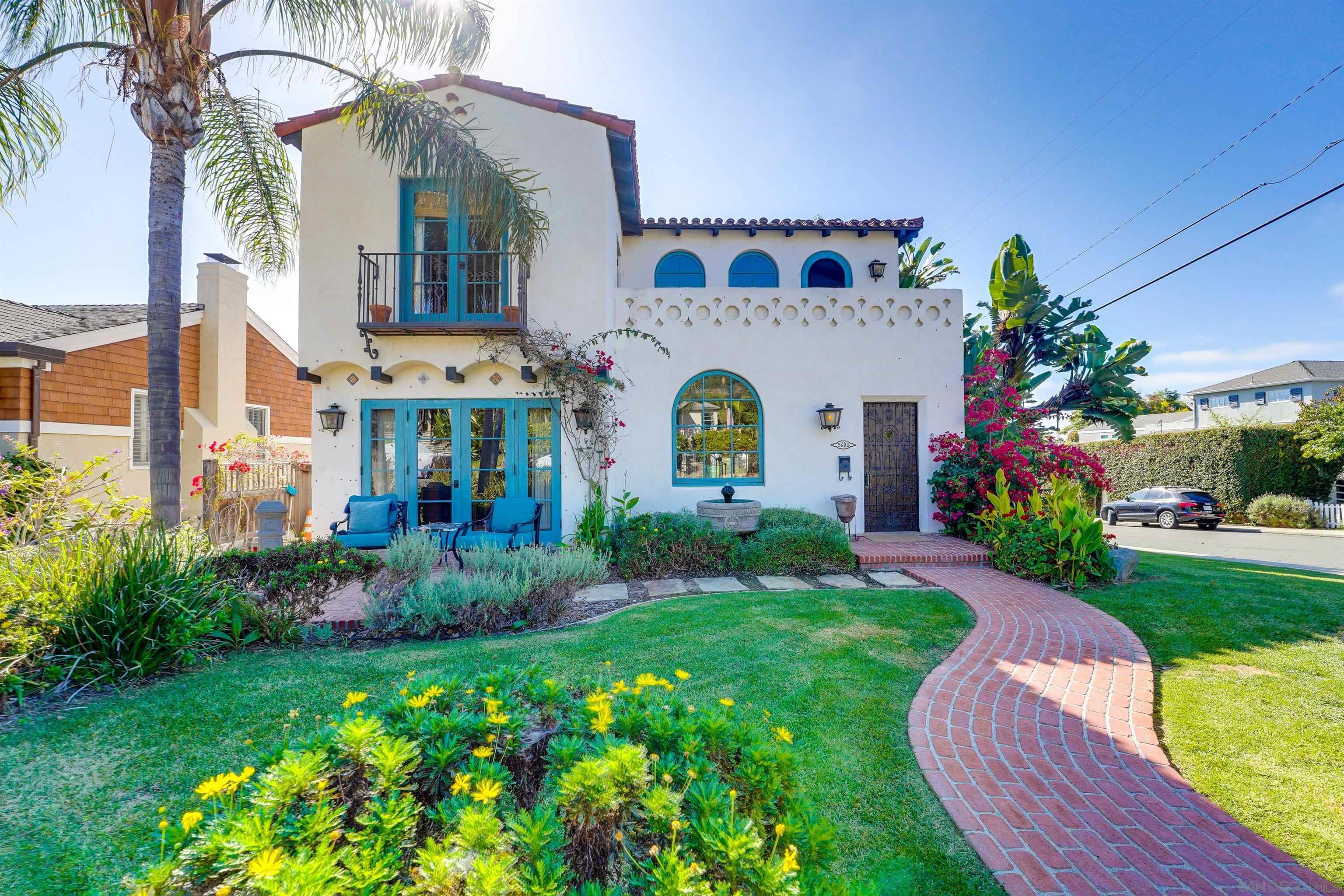 a view of a white house with a big yard and potted plants