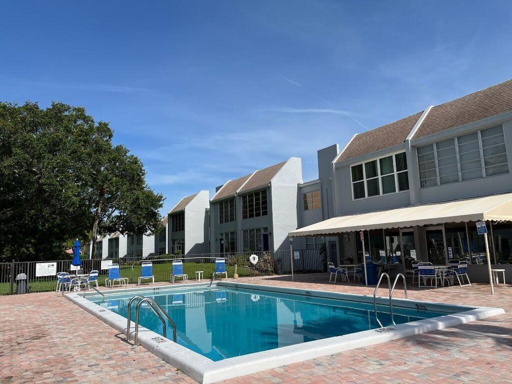 a view of a house with swimming pool and sitting area