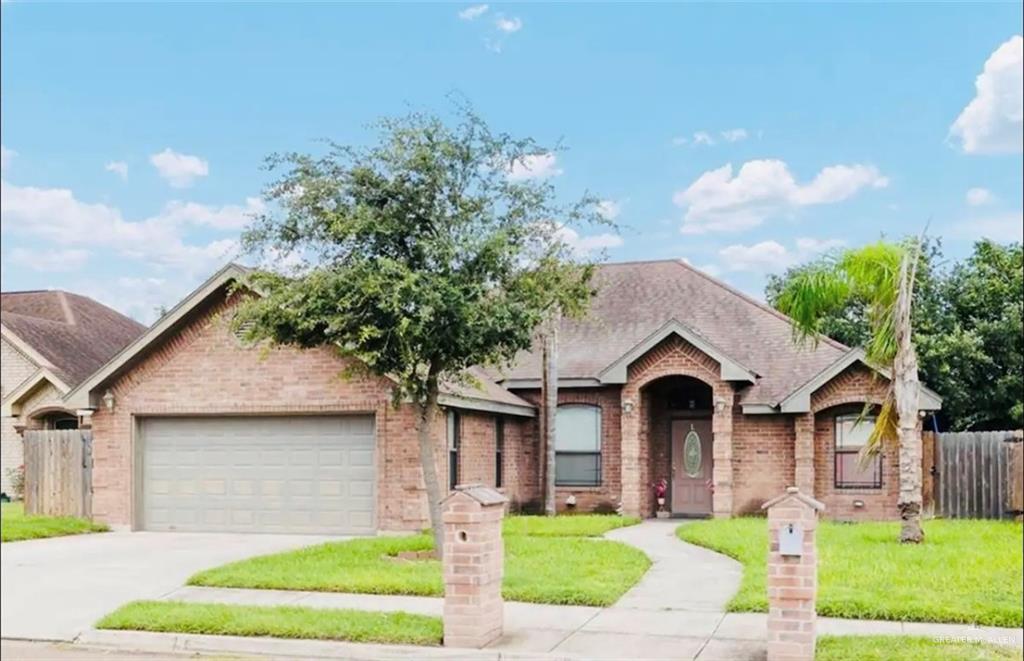 View of front facade featuring a garage and a front yard