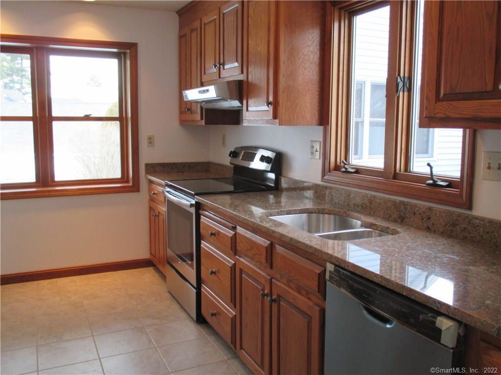 a kitchen with stainless steel appliances granite countertop a sink a stove and a microwave