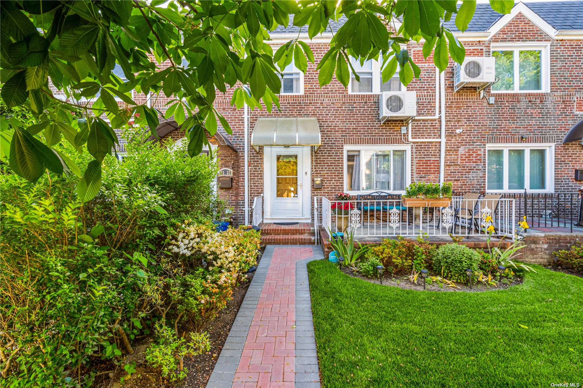 a view of a house with a yard and potted plants