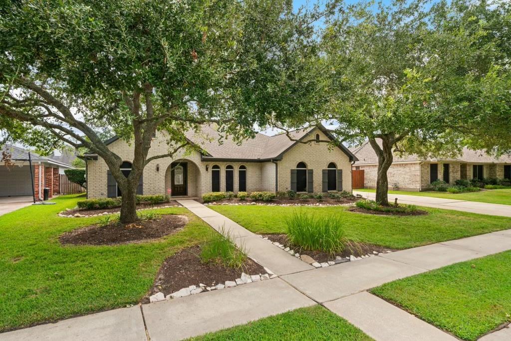 a front view of a house with a yard and garden