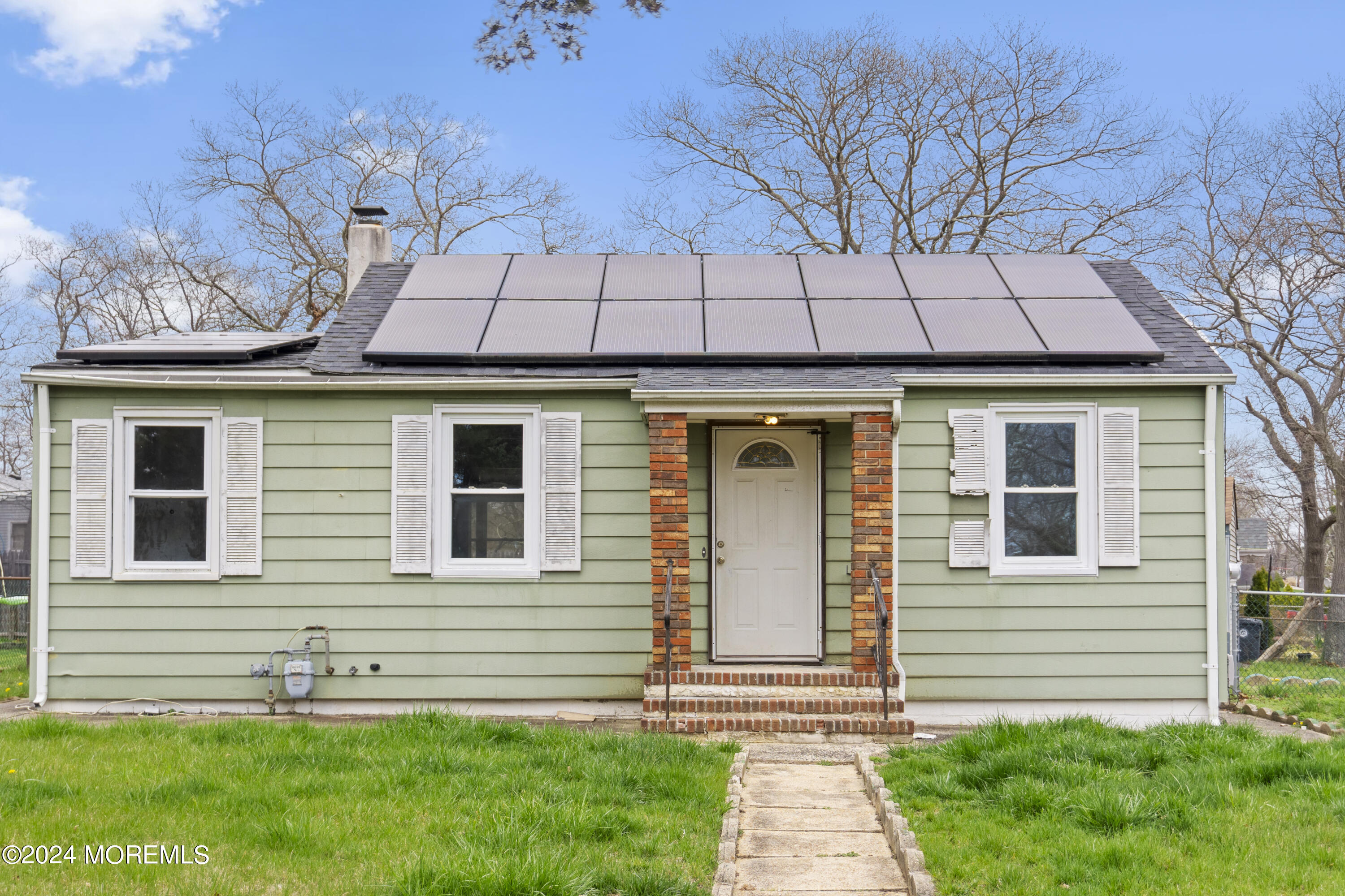 a front view of a house with a yard and outdoor seating