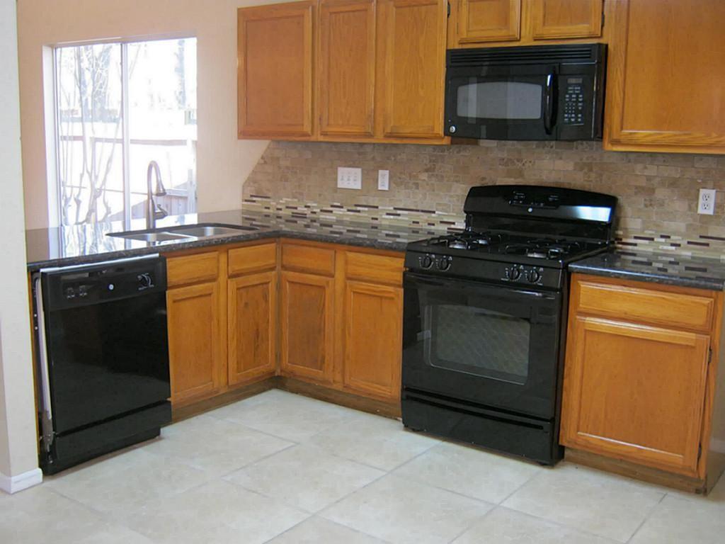 a kitchen with granite countertop cabinets stainless steel appliances and a window