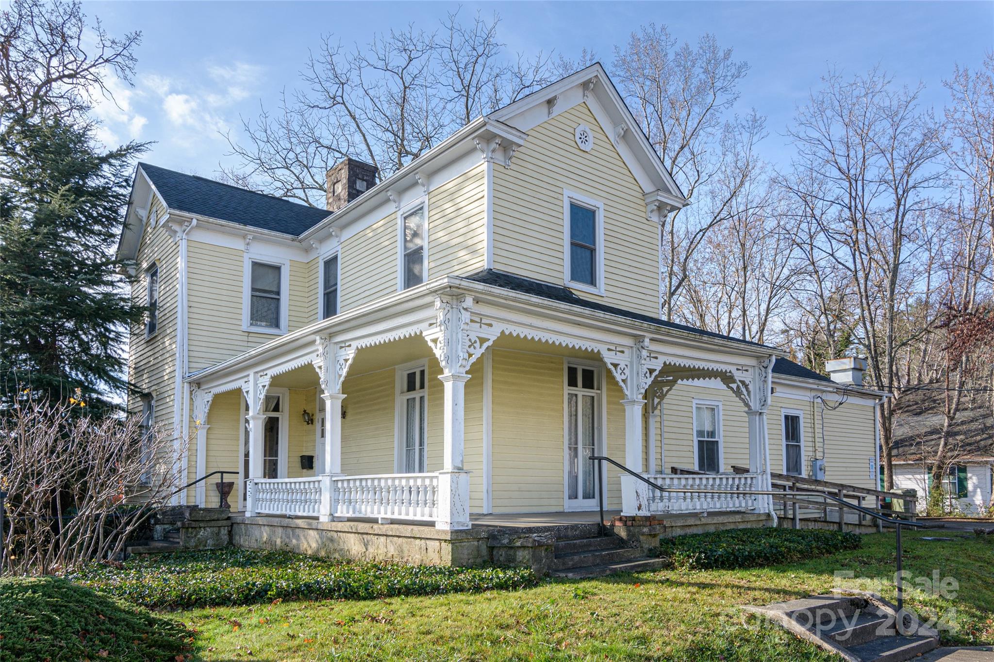 a view of a white house with a yard and plants