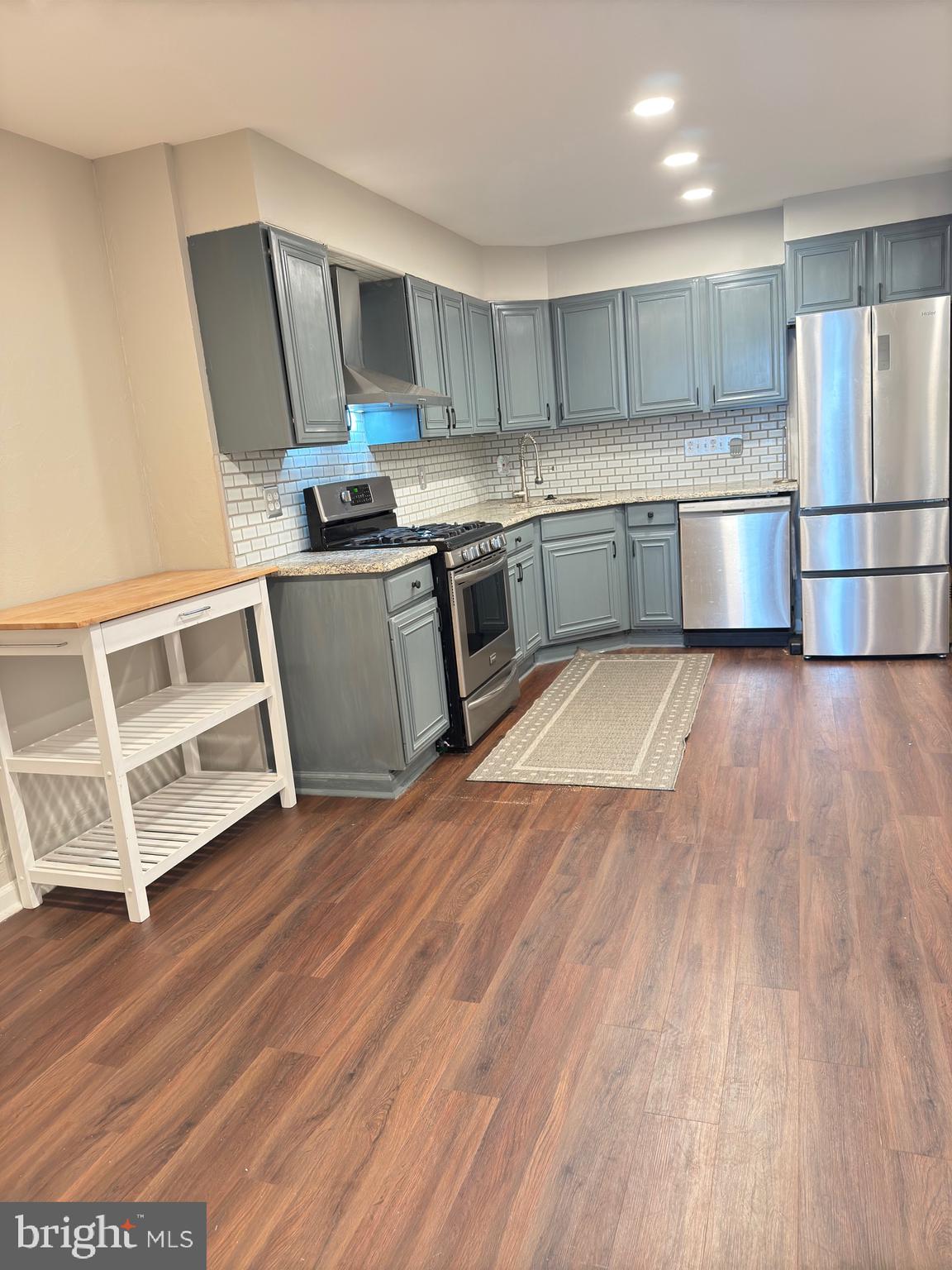 a kitchen with wooden floors and appliances