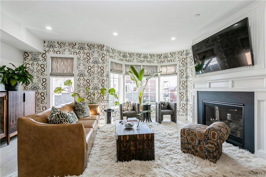 a living room with furniture a flat screen tv and a fireplace