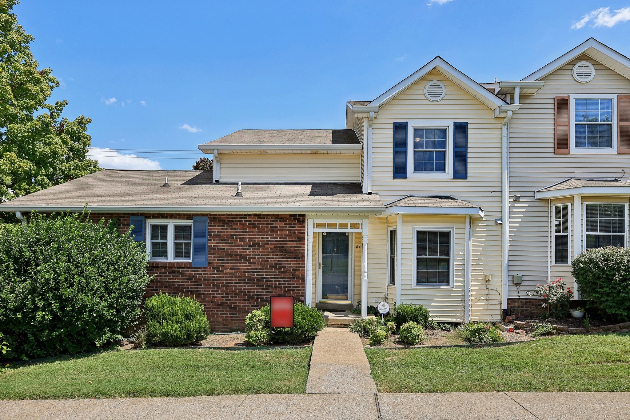 a front view of a house with a yard and potted plants