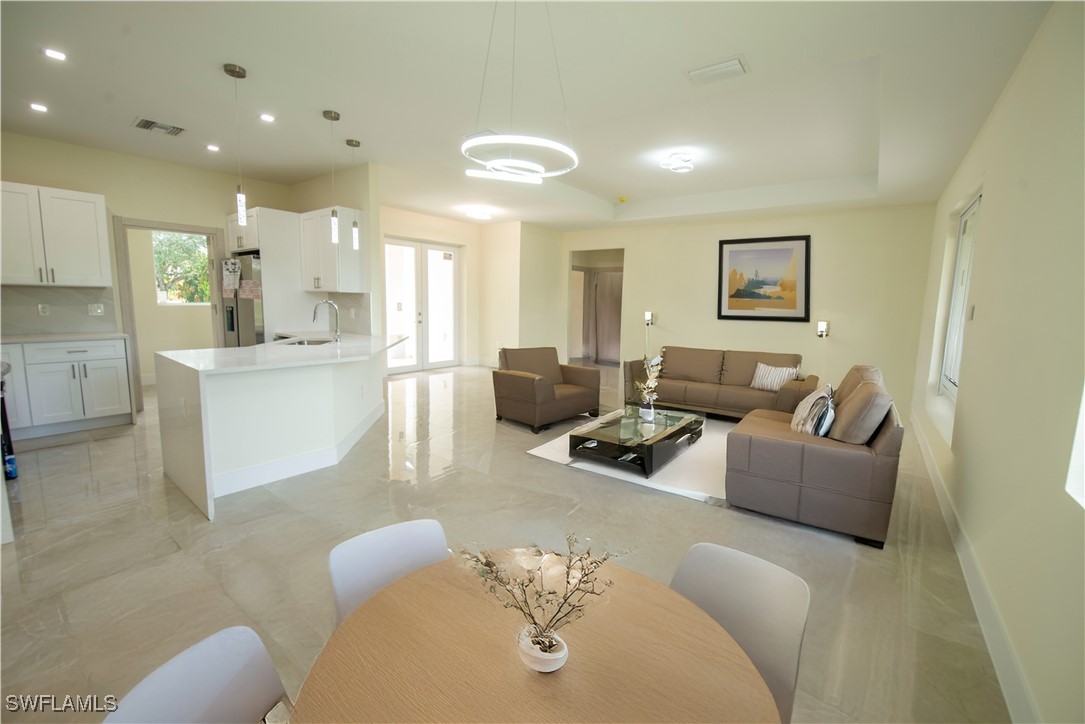 a living room with furniture and a dining table with kitchen view